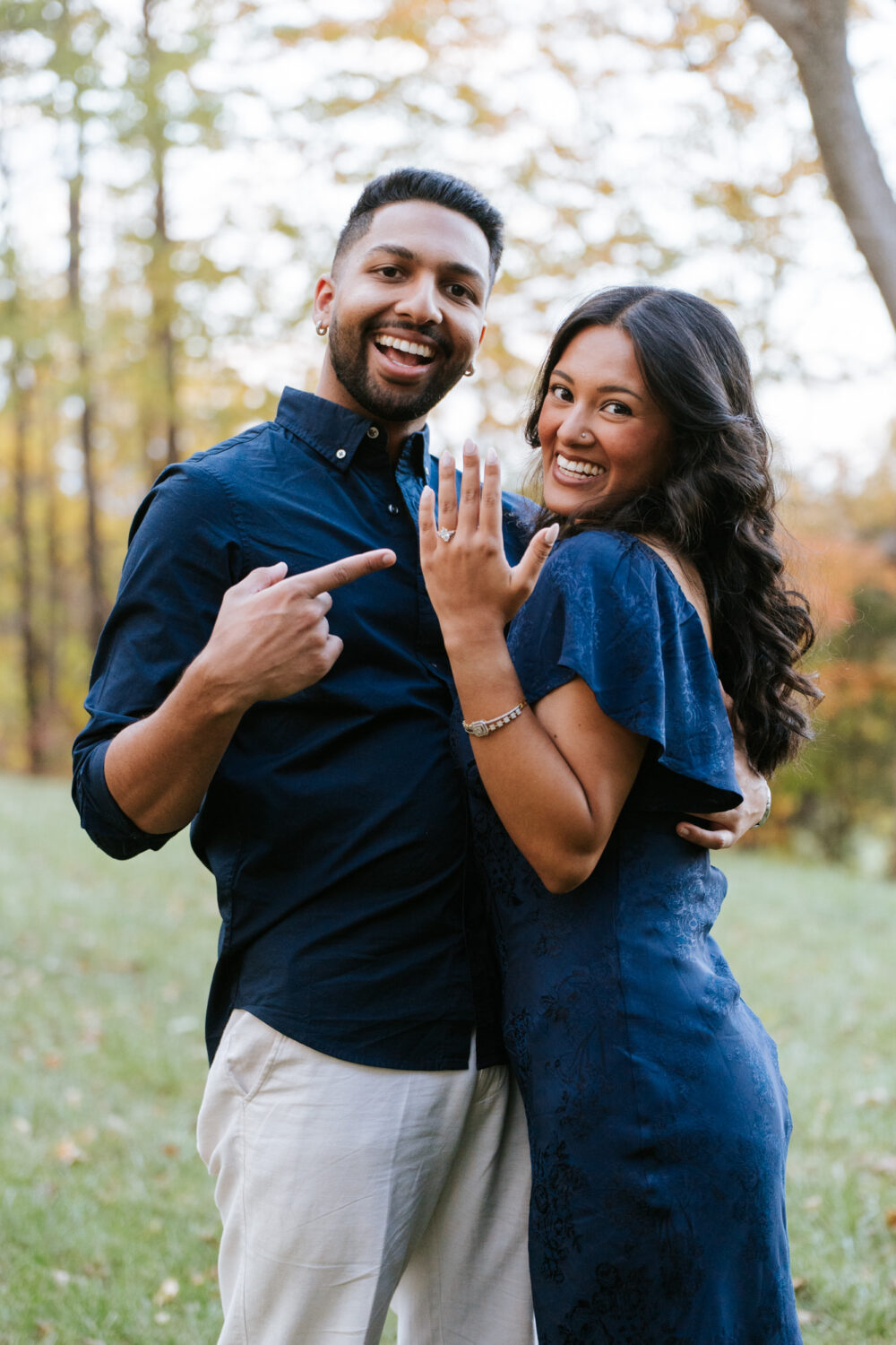 Couple celebrating their surprise proposal as bride-to-be shows off her ring