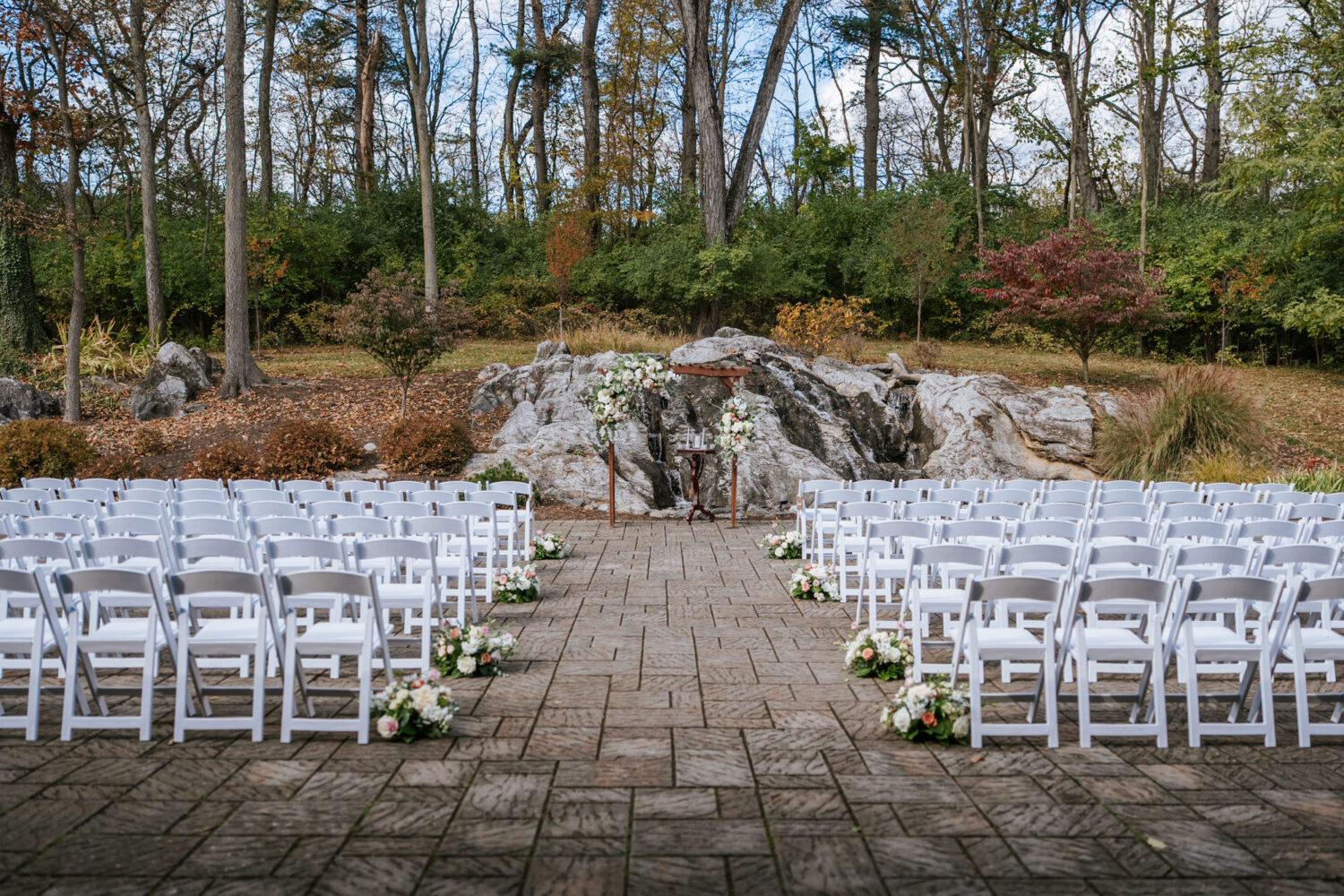 Outdoor ceremony setup with waterfall backdrop at Rosemont Springs wedding venue
