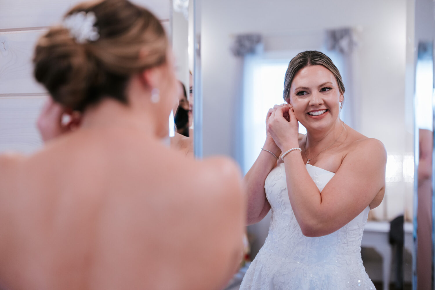 Bride putting on earrings while getting ready at Rosemont Springs
