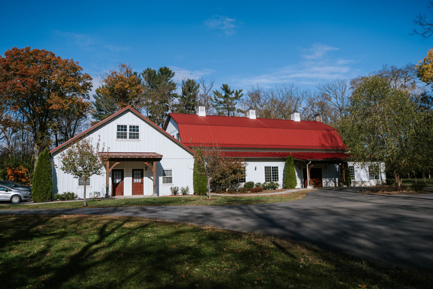 Exterior view of the Rosemont Springs wedding venue with red roof and fall trees
