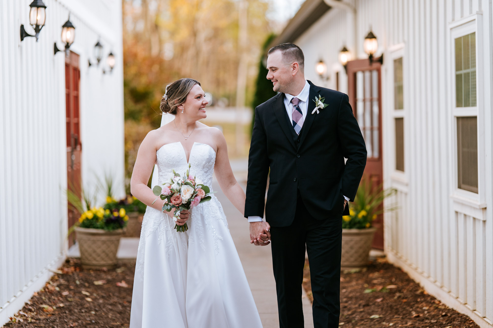 Bride and groom walking together outside the barn at their Rosemont Springs wedding