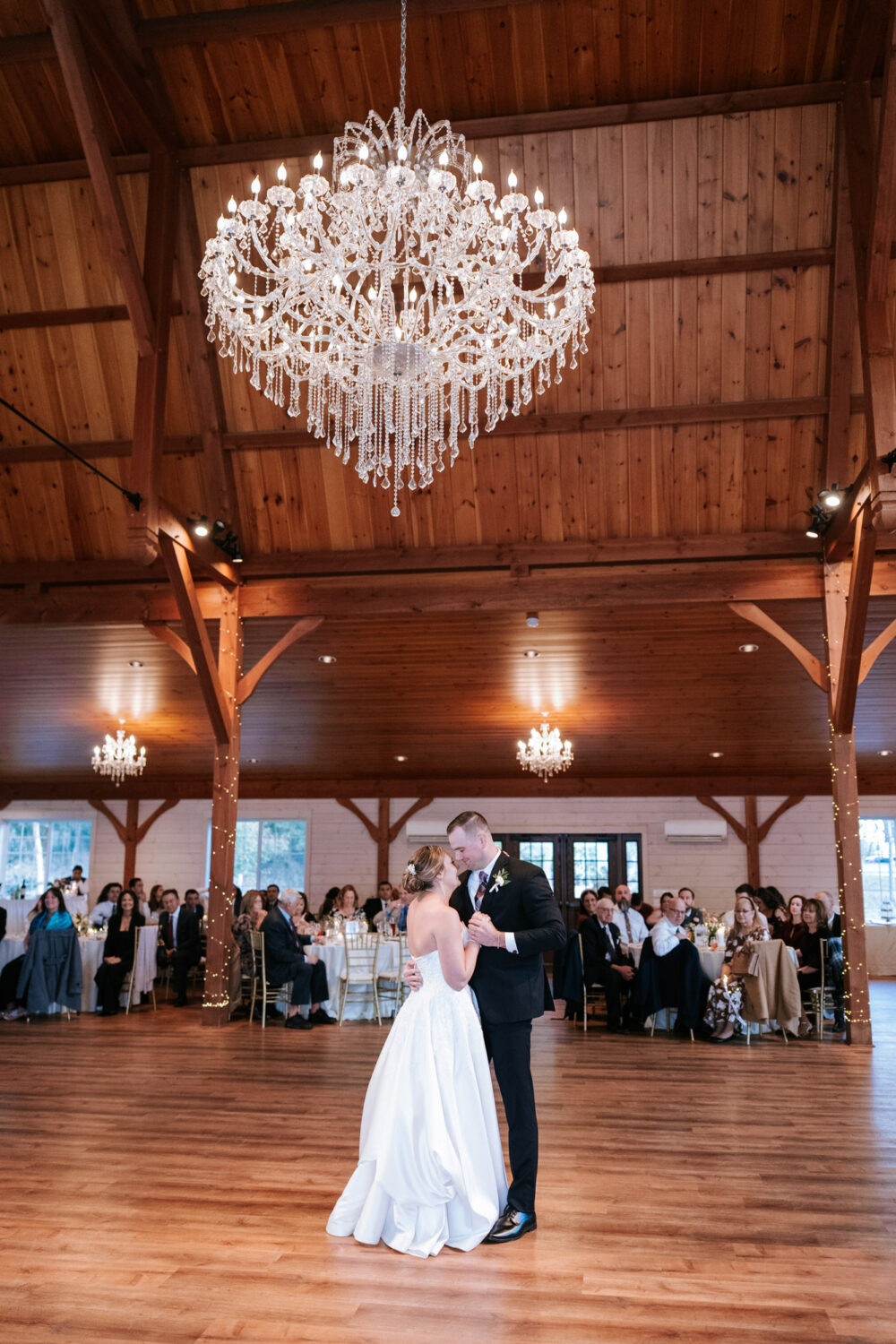 First dance under chandelier at Rosemont Springs barn reception
