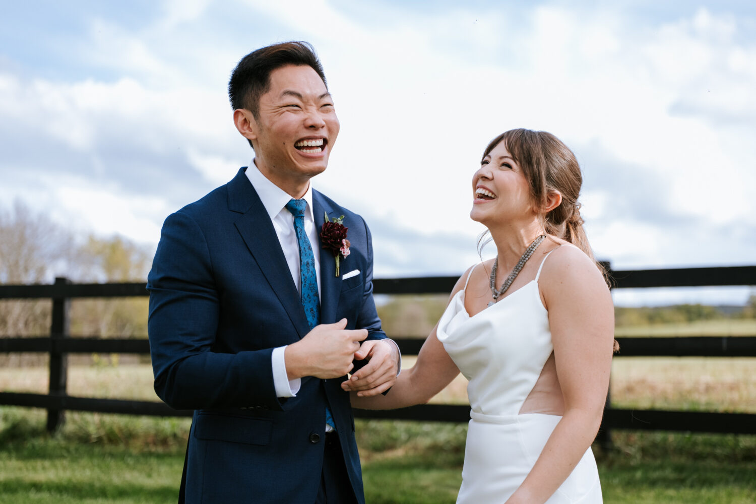 Couple laughing together during candid first look on their wedding day
