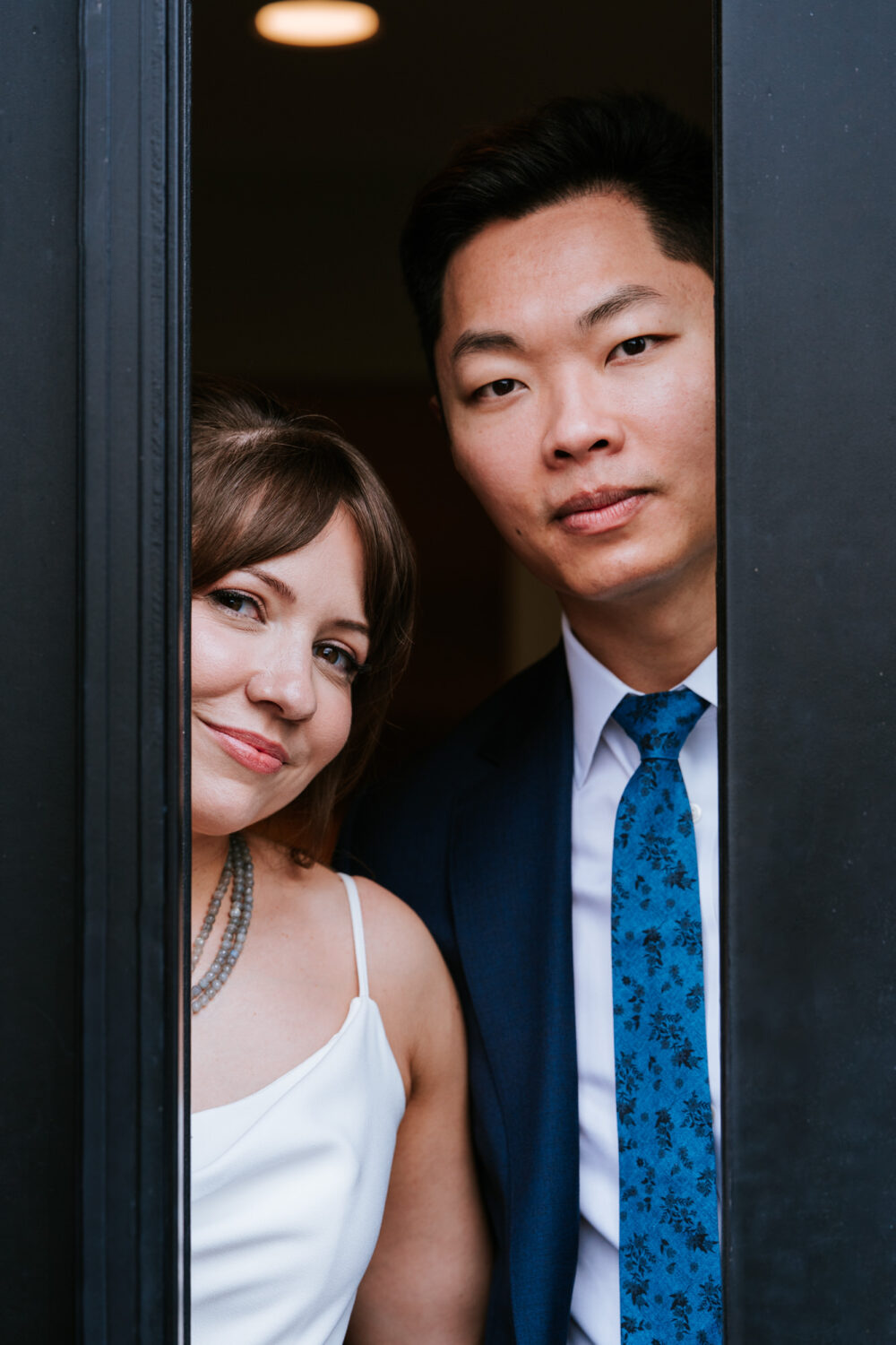 Creative close-up of bride and groom peeking through doorway
