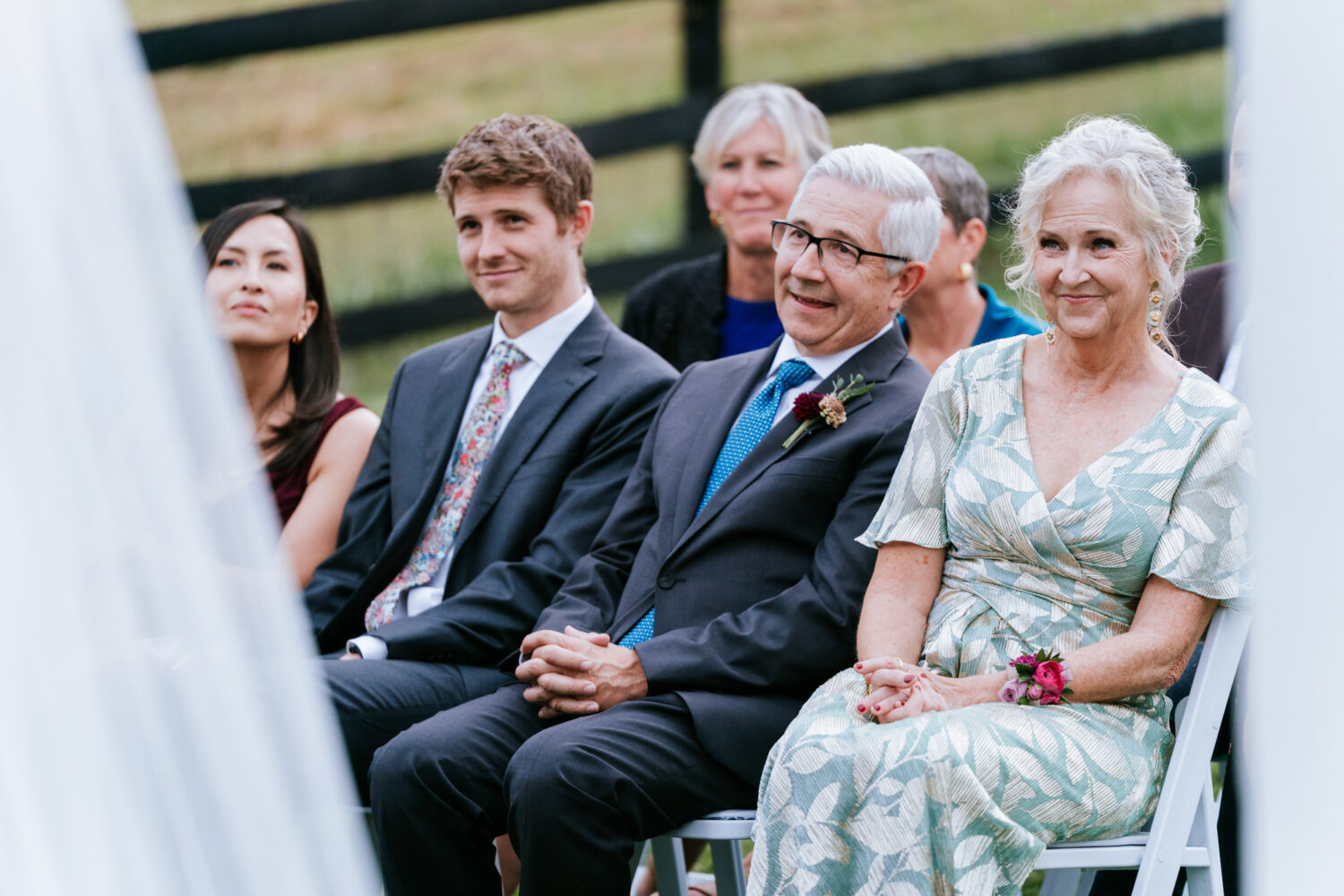 Family members smiling and watching the ceremony unfold
