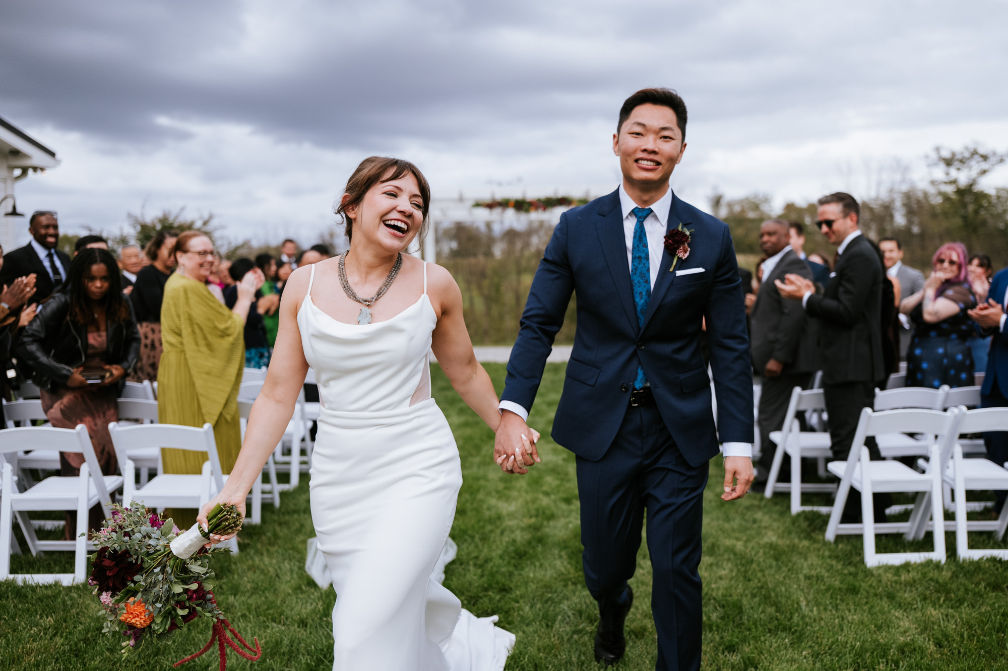 Bride and groom walking back down the aisle, smiling and celebrating during their willow brook wedding day in Leesburg VA