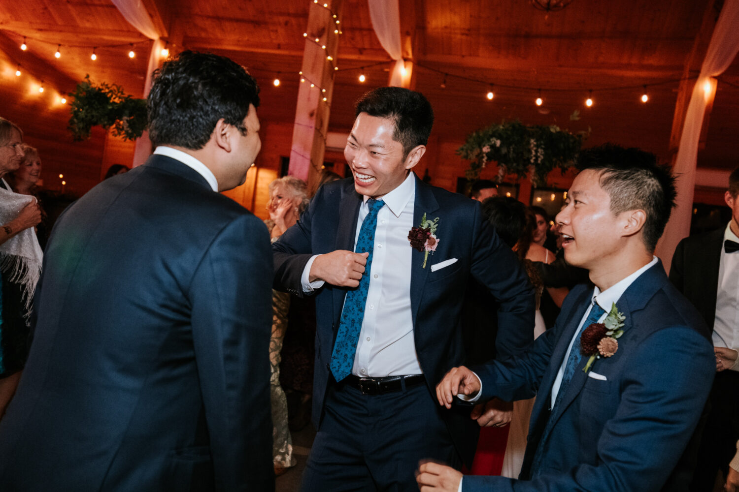 Groom dancing and celebrating with friends during reception
