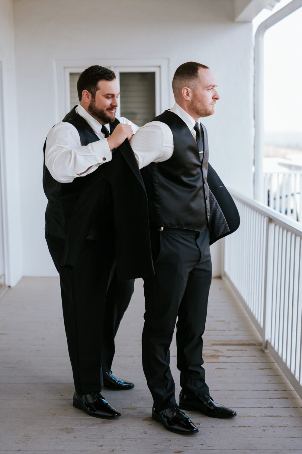 Groom getting help putting on jacket at The View at Bluemont wedding