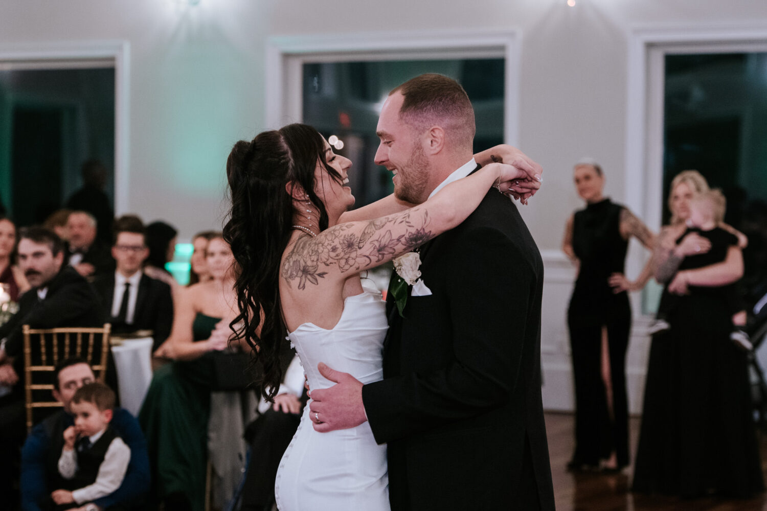 Bride and groom smiling during first dance at wedding reception
