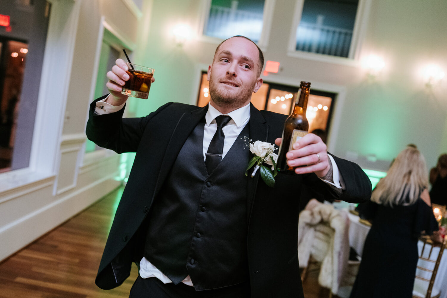 Groom celebrating with drinks on dance floor wedding reception