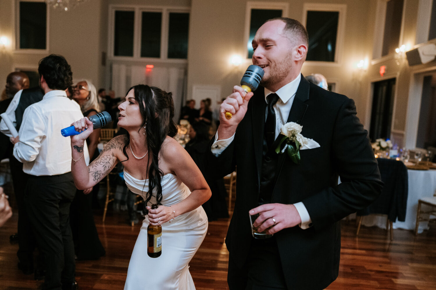 Bride and groom singing karaoke together at wedding reception
