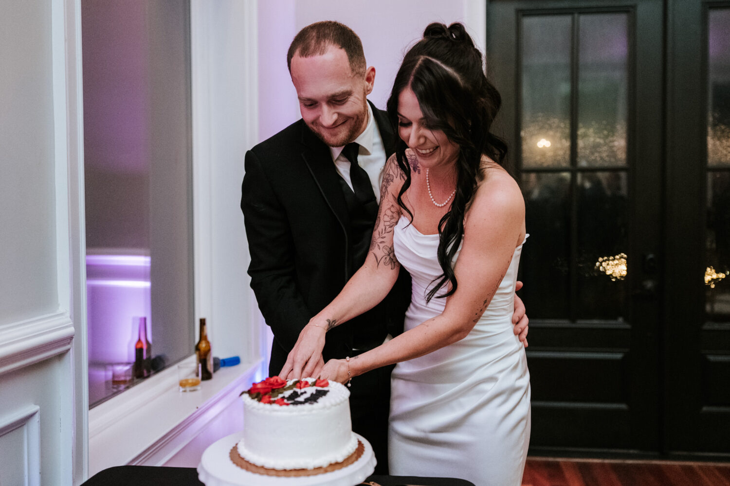 Bride and groom cutting wedding cake together