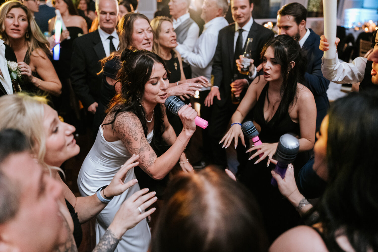 Bride singing with guests on dance floor wedding reception