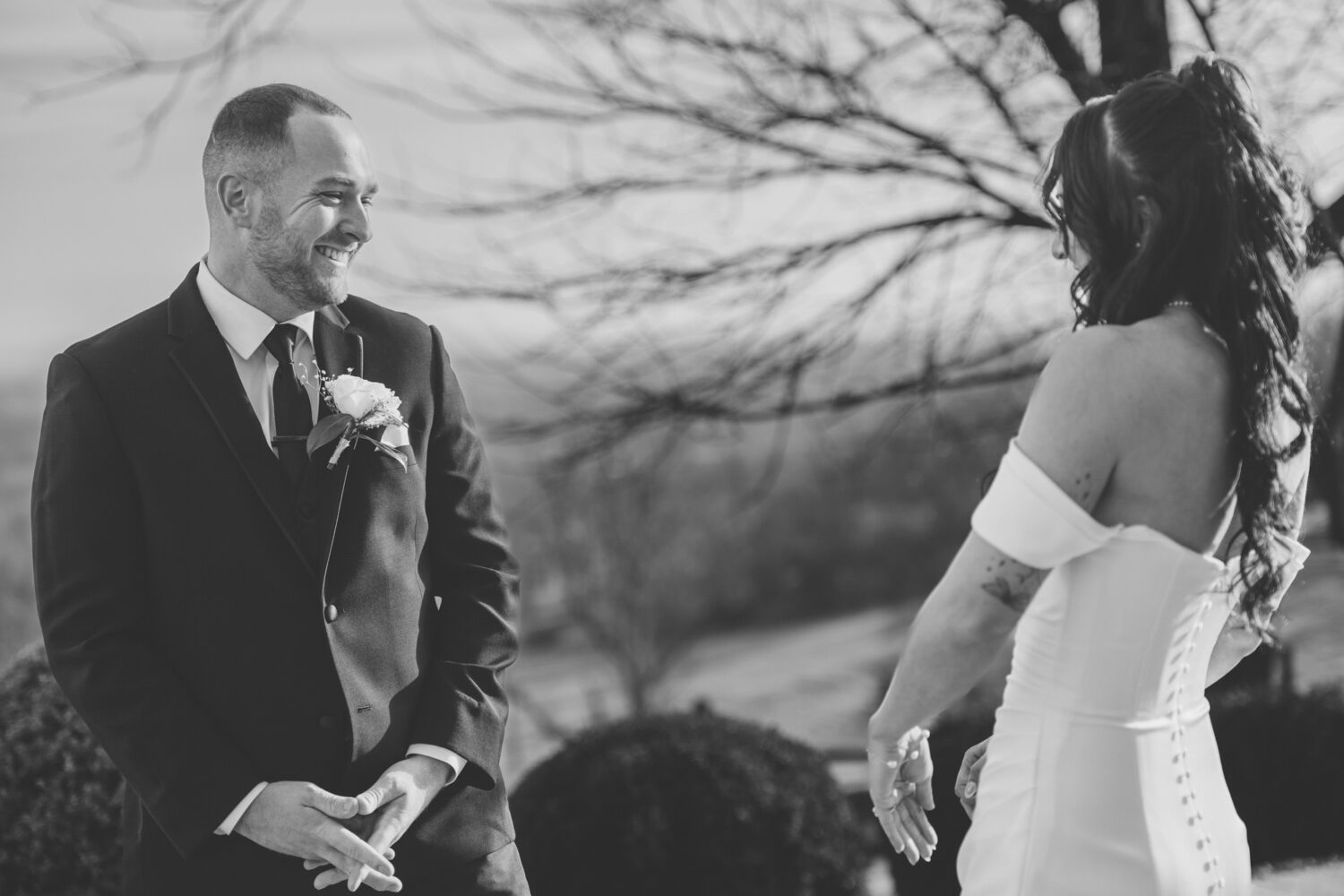 Candid black and white photo of bride and groom sharing a moment at wedding